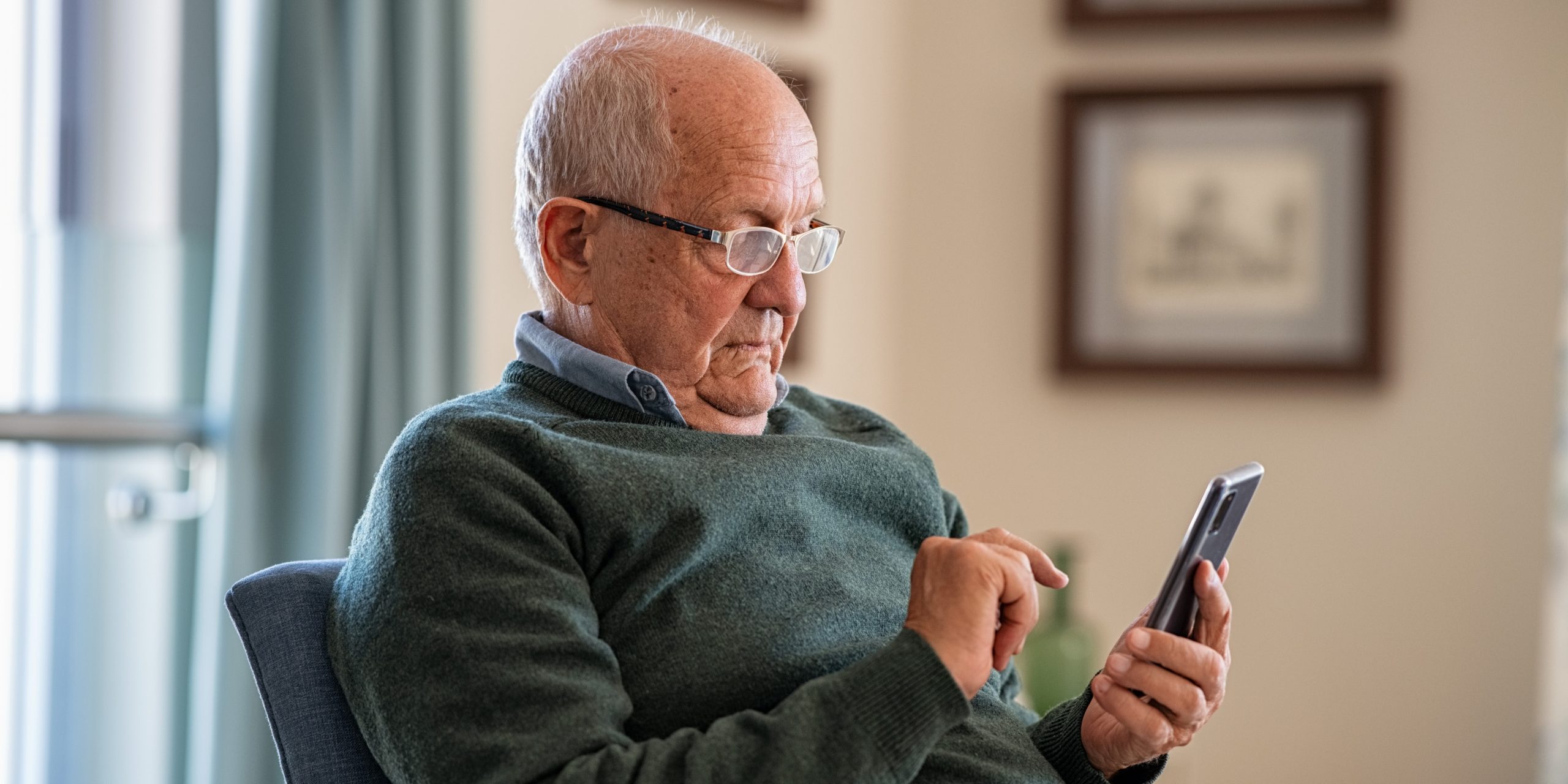 Senior man using smartphone at home